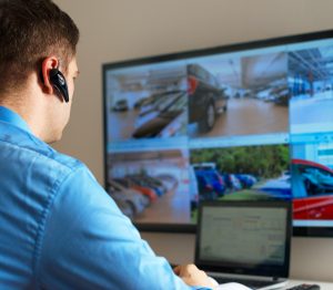 Security guard monitoring video in security room.